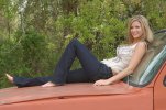 young blonde woman in jeans reclining on orange pickup truck 02.jpg