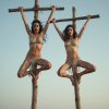 two_crucified_woman_crucified_side_by_side_on_two_separated_crosses_arched_back_arms_straight_...png