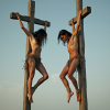 perpendicular_side_view_two_crucified_woman_in_2_crosses_against_the_sky_background_ragged_bro...png